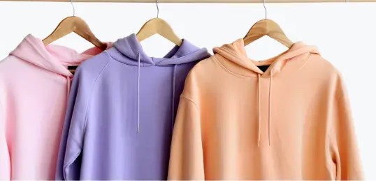 Abschluss-Hoodies in Rosa, Lila und Apricot auf Kleiderbügeln